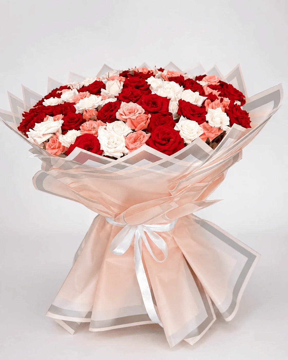 Red, pink and white rose bouquet in layered blush wrapping, available for delivery in Fes